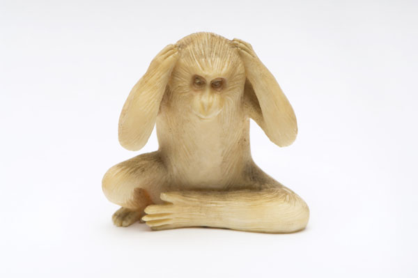 An ivory monkey covering its ears, 'hear no evil' style